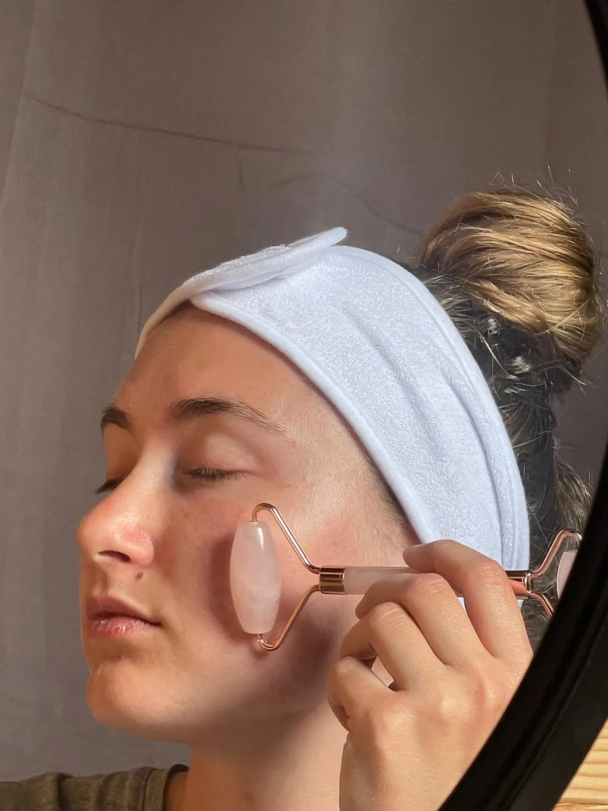 une personne utilise un rouleau massant sur le visage